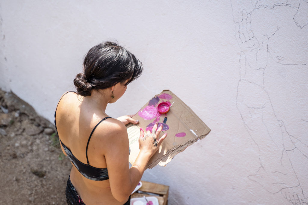 A traveling artist painting a mural.